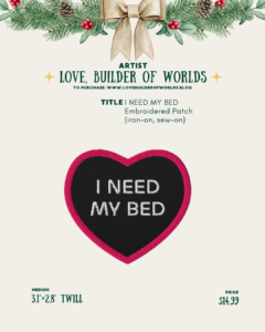 [id:A holiday-themed product page for Love, Builder of Worlds showing a heart-shaped embroidered patch. The patch has a black background with white stitched text that reads “I NEED MY BED,” surrounded by a bright pink border. The patch size is 3.1” × 2.8” twill, priced at $14.99.]